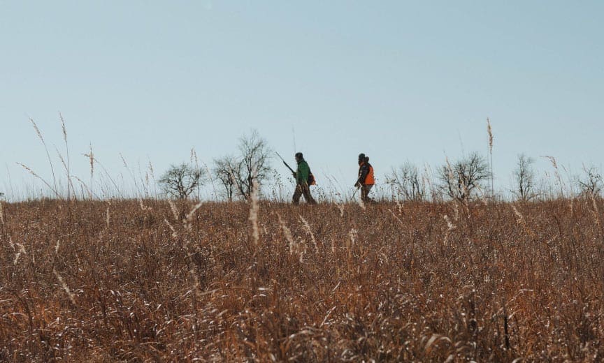 Bird hunters waking on the prairie